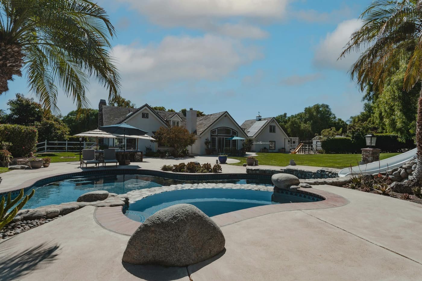 A freeform backyard pool with a raised spa and boulder accents